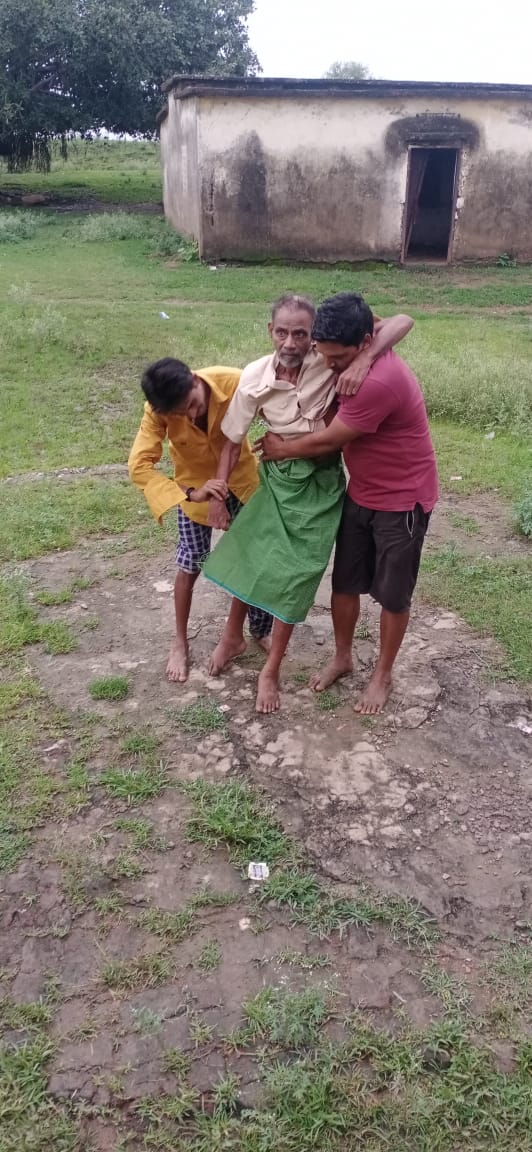 टीकाकरण केंद्र तक गाड़ी नहीं पहुंचने पर लकवाग्रस्त बुजुर्ग को कांधे में लाकर टिका लगवाते दिखे